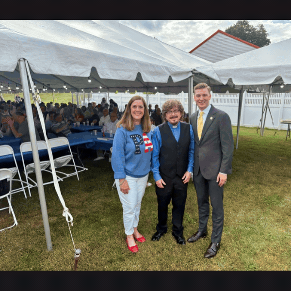 Slideshow of Sen. Baker with Rev. Gurka, Rep. Ryncavage, and community members at St. John bazar grounds.