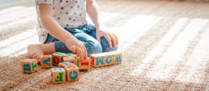 Young child is playing with colorful wooden blocks.