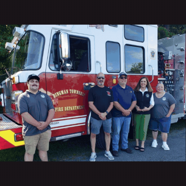 Township police officers and firefighters from Dallas, Dingman, and Newport townships stand near their various emergency vehicles on display during National Night Out, community members walking around the display